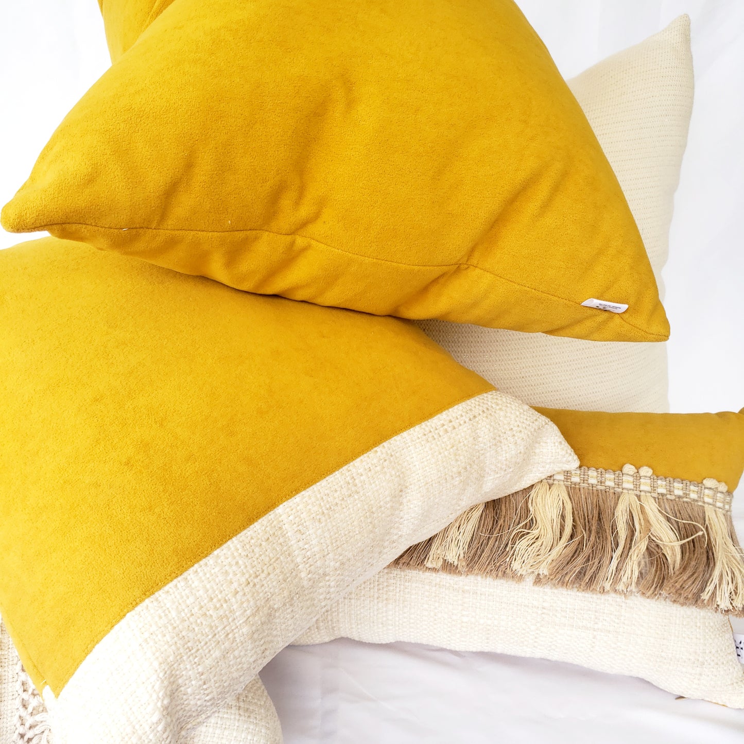 Elevate your home decor with our Fiokim Mustard Deluxe Square Pillow Cover. Crafted with luxurious mustard suede-like fabric, this designer pillow features a sophisticated woven ivory and beige design. Perfect for your sofa or bedroom, its matching reverse and double stitched, sealed edges add a touch of elegance. The invisible zipper ensures a seamless and polished look.
Mustard yellow square pillows